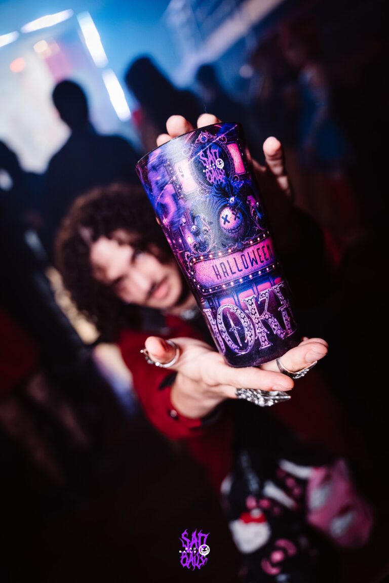 Garota segura copo Joker em primeiro plano — Sad Baile Joker, Halloween em São Paulo, 17/10/2026