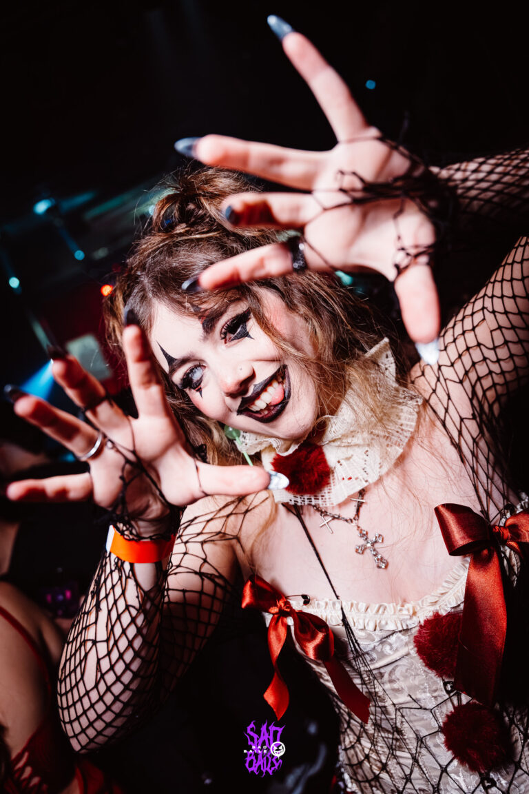 Garota fantasiada de boneca estende as mãos — Sad Baile Joker, Halloween em São Paulo, 17/10/2026