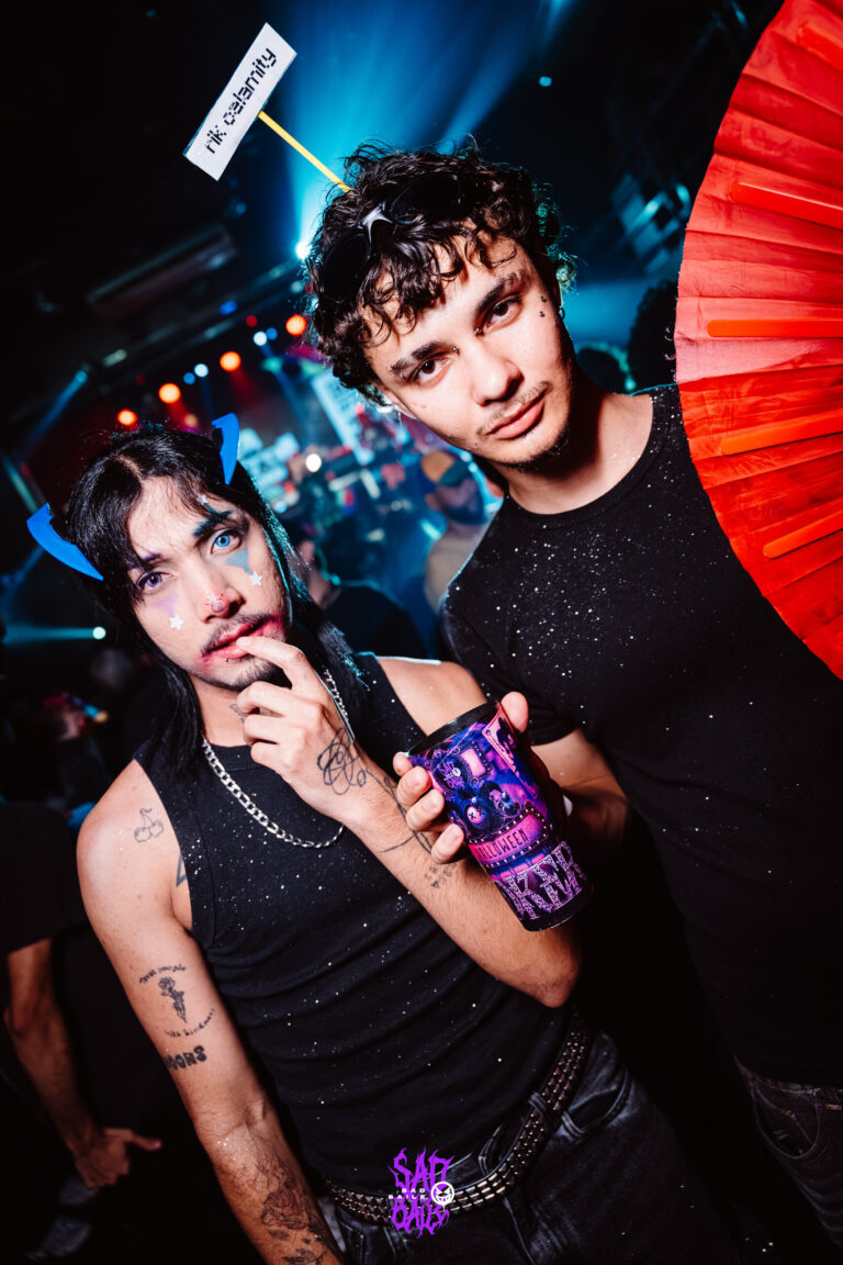 Rapaz de regata preta posa com leque vermelho — Sad Baile Joker, Halloween em São Paulo, 17/10/2026
