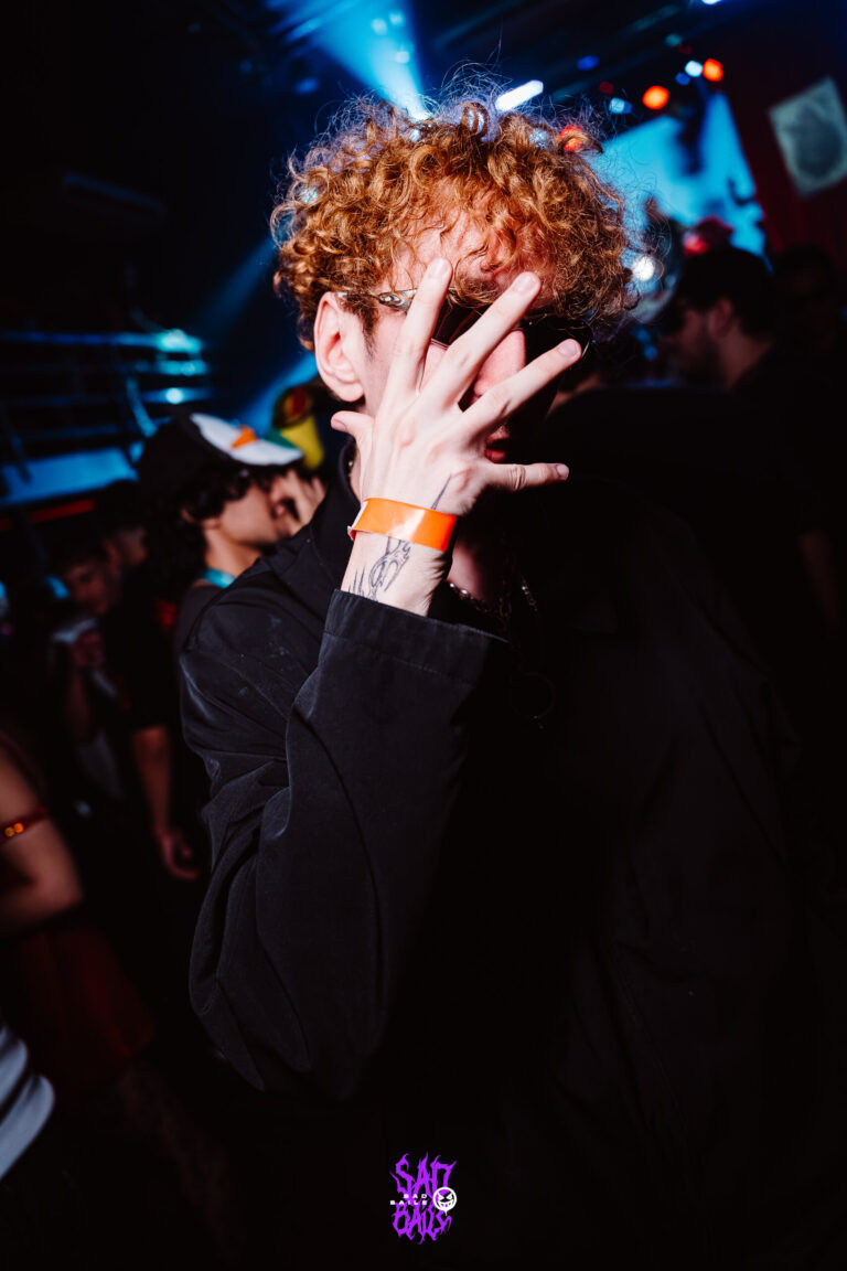 Rapaz de cabelo ruivo cobre o rosto com a mão — Sad Baile Joker, Halloween em São Paulo, 17/10/2026