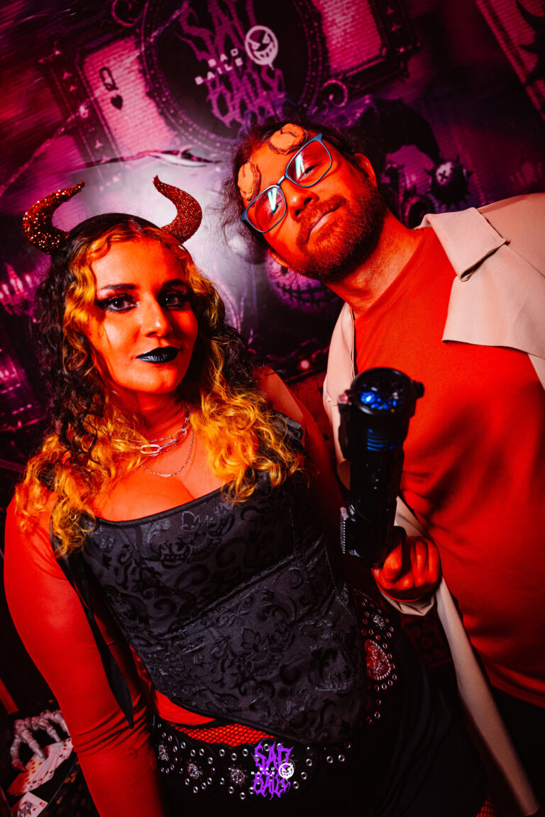 Casal de diabos com chifres sob luz vermelha — Sad Baile Joker, Halloween em São Paulo, 17/10/2026