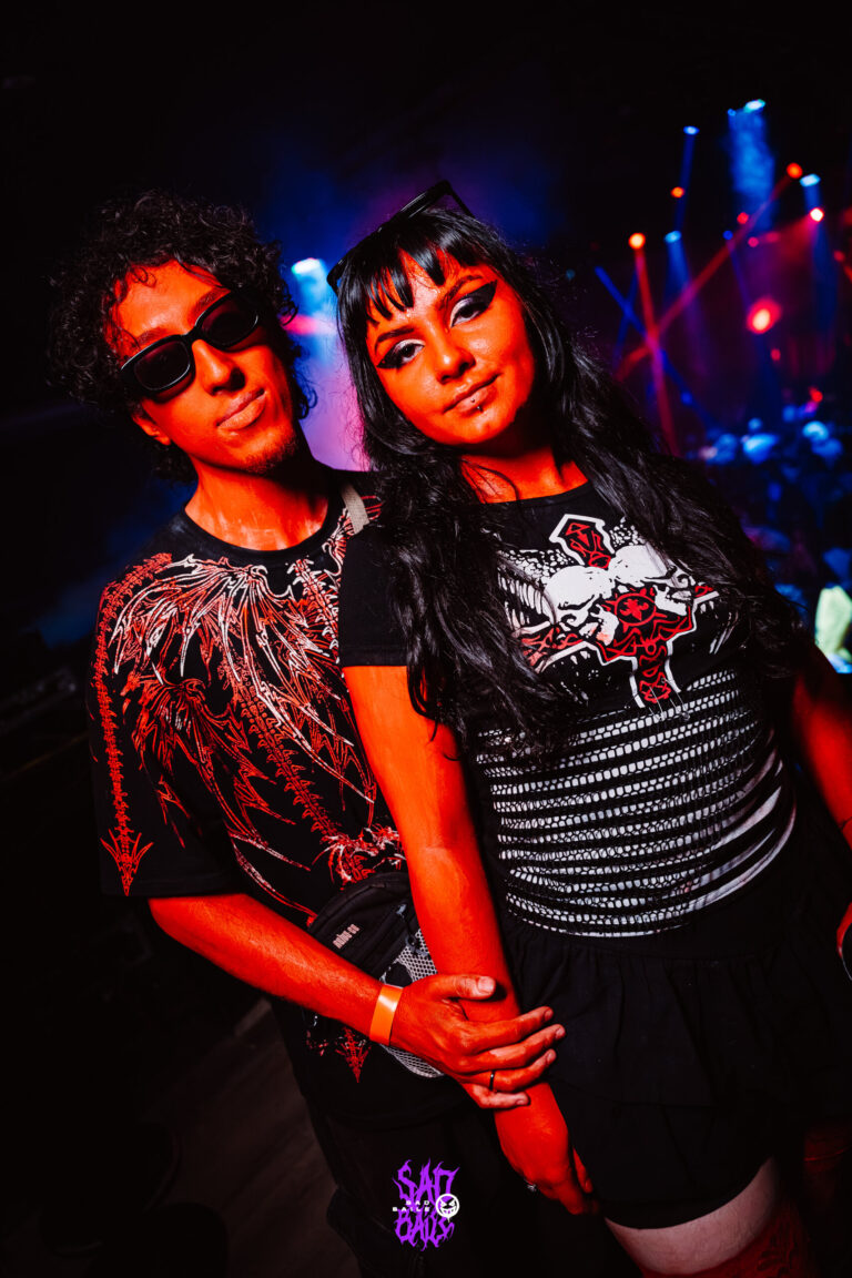 Casal de óculos escuros sob luz vermelha — Sad Baile Joker, Halloween em São Paulo, 17/10/2026