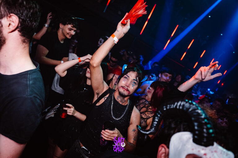 Galera mascarada levanta os braços na pista — Sad Baile Joker, Halloween em São Paulo, 17/10/2026