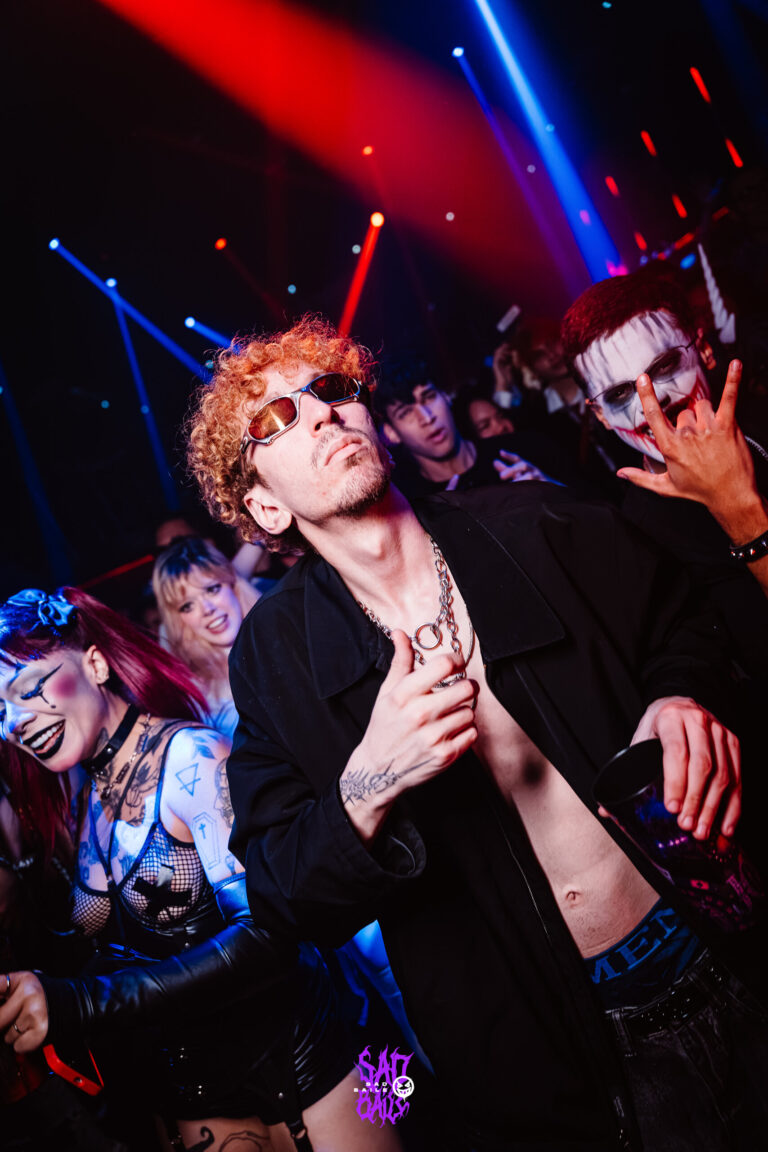Rapaz de cabelo cacheado dança sob luz vermelha — Sad Baile Joker, Halloween em São Paulo, 17/10/2026