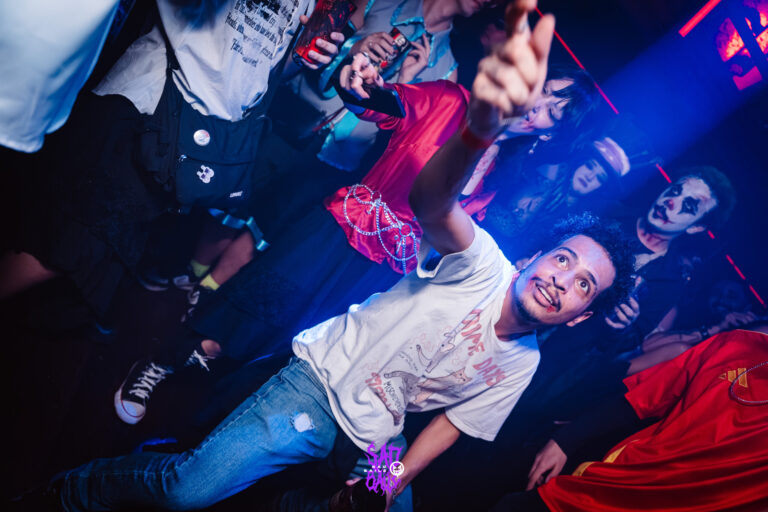 Rapaz de camiseta branca aponta para a câmera — Sad Baile Joker, Halloween em São Paulo, 17/10/2026