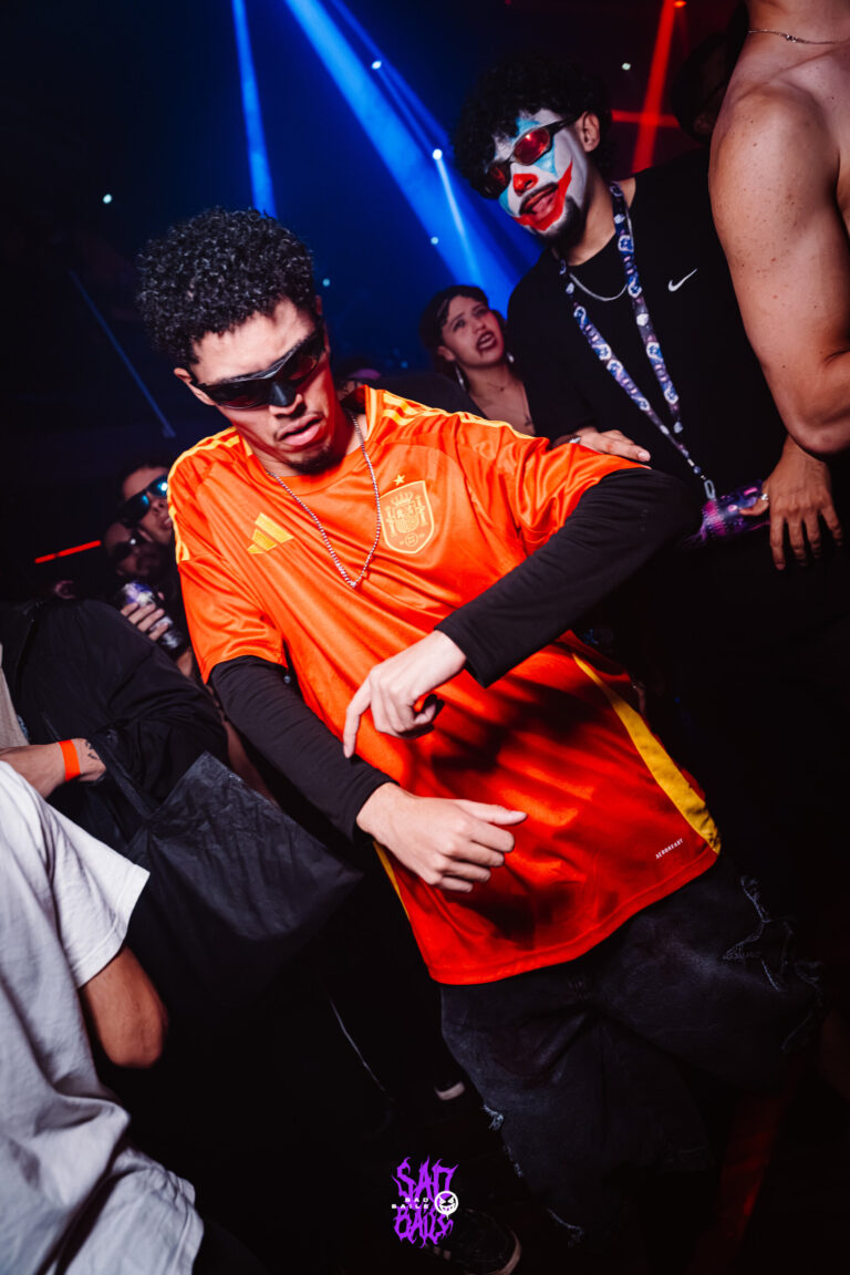 Rapaz de camisa de time laranja faz pose — Sad Baile Joker, Halloween em São Paulo, 17/10/2026