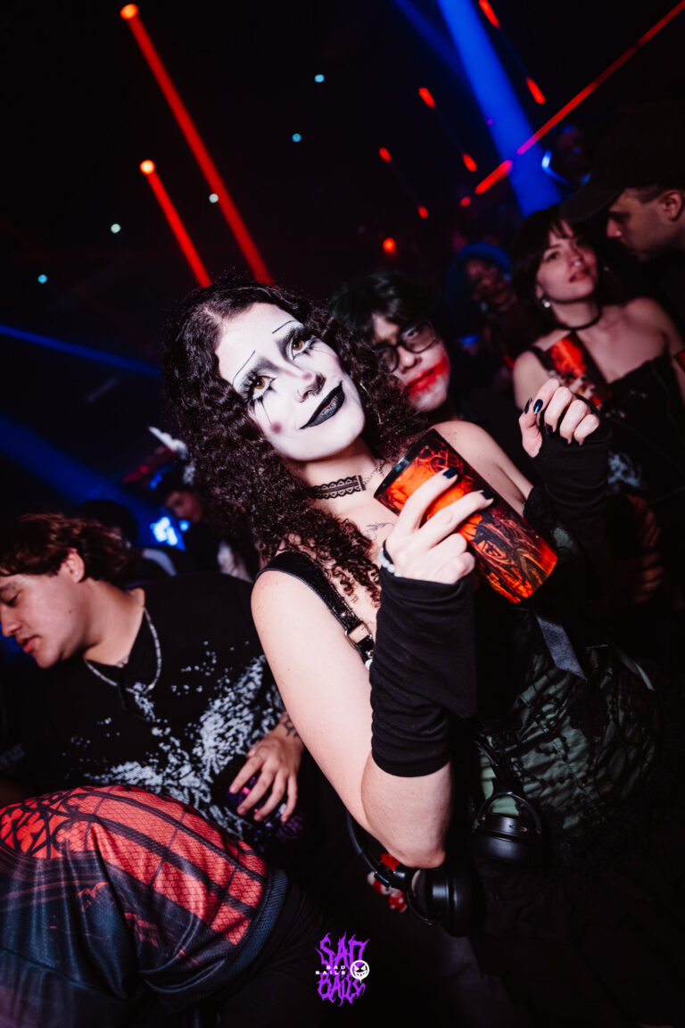 Garota de maquiagem branca segura copo na pista — Sad Baile Joker, Halloween em São Paulo, 17/10/2026