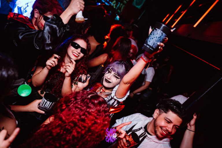 Amigos erguem copos na pista lotada — Sad Baile Joker, Halloween em São Paulo, 17/10/2026