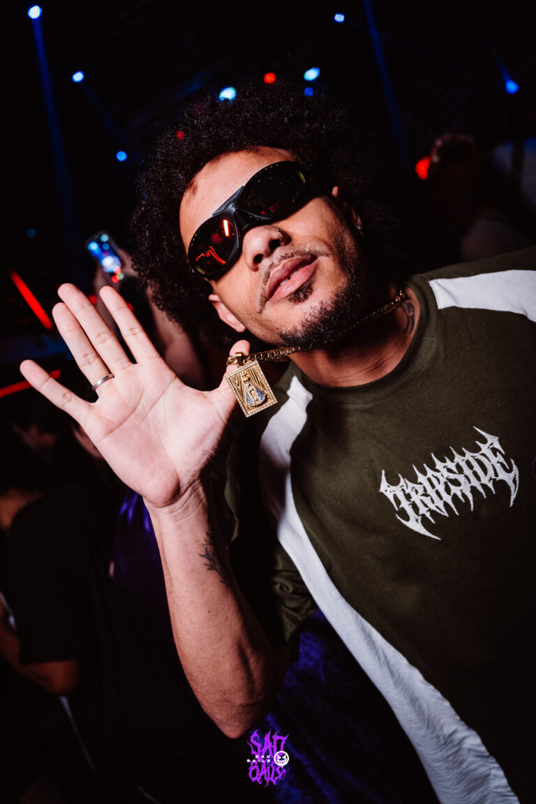 Rapaz de óculos escuros acena para a câmera — Sad Baile Joker, Halloween em São Paulo, 17/10/2026