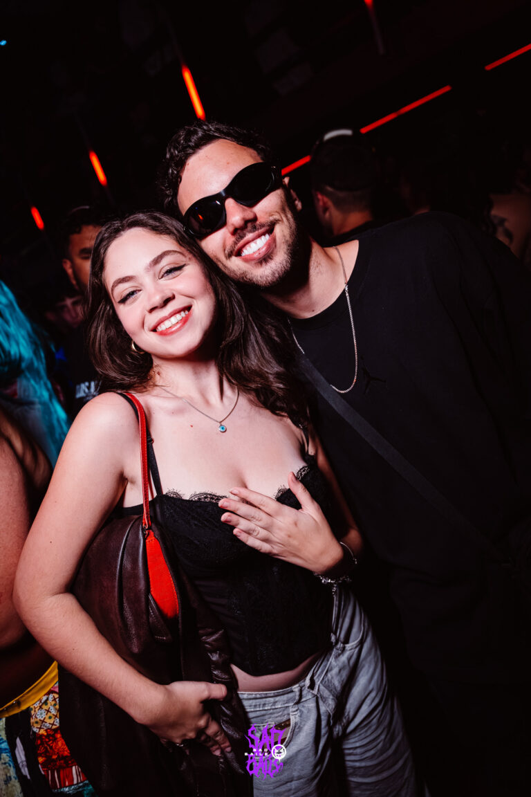 Casal sorri na pista, ele de óculos escuros — Sad Baile Joker, Halloween em São Paulo, 17/10/2026