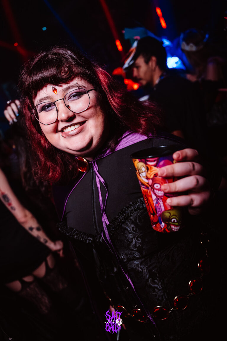 Garota de óculos e cabelo vermelho com copo — Sad Baile Joker, Halloween em São Paulo, 17/10/2026