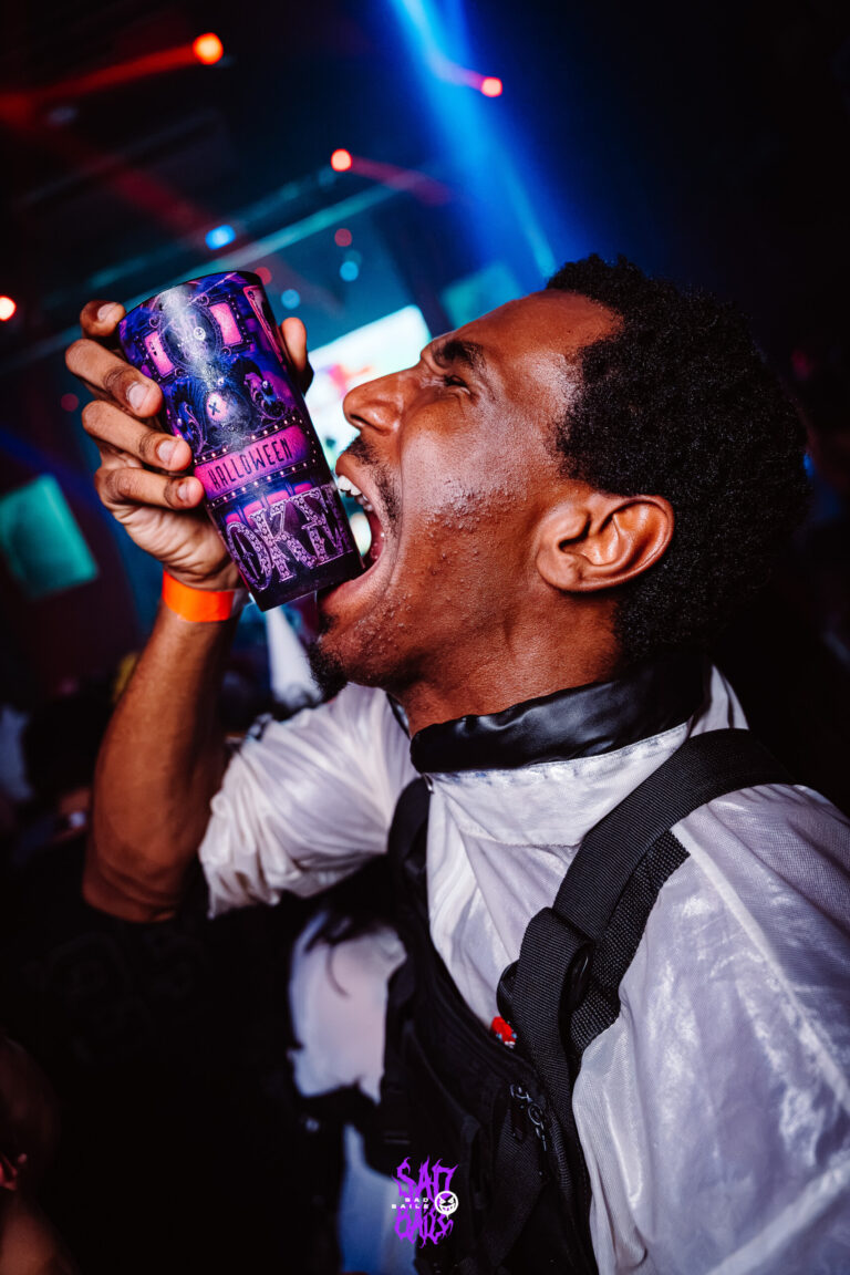 Rapaz de suspensórios bebe no copo Joker — Sad Baile Joker, Halloween em São Paulo, 17/10/2026