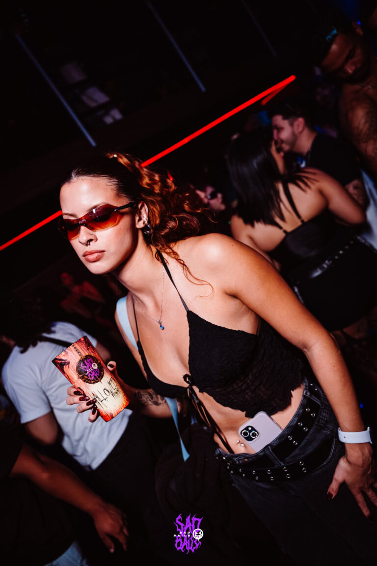 Garota de óculos escuros com copo na pista — Sad Baile Joker, Halloween em São Paulo, 17/10/2026