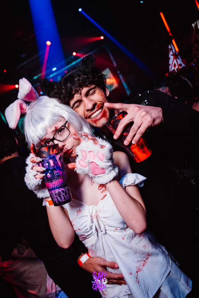 Garota de peruca branca e laço segura copo Joker — Sad Baile Joker, Halloween em São Paulo, 17/10/2026
