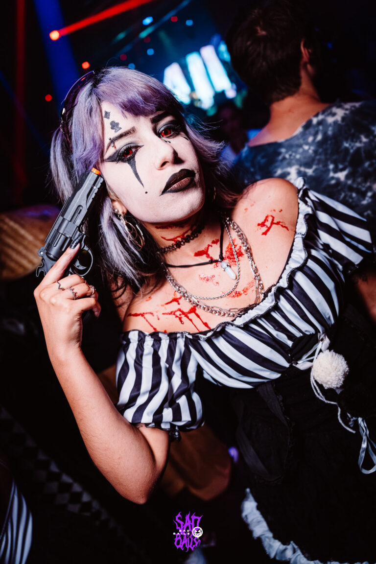 Palhaça de cabelo lilás aponta arma de brinquedo — Sad Baile Joker, Halloween em São Paulo, 17/10/2026