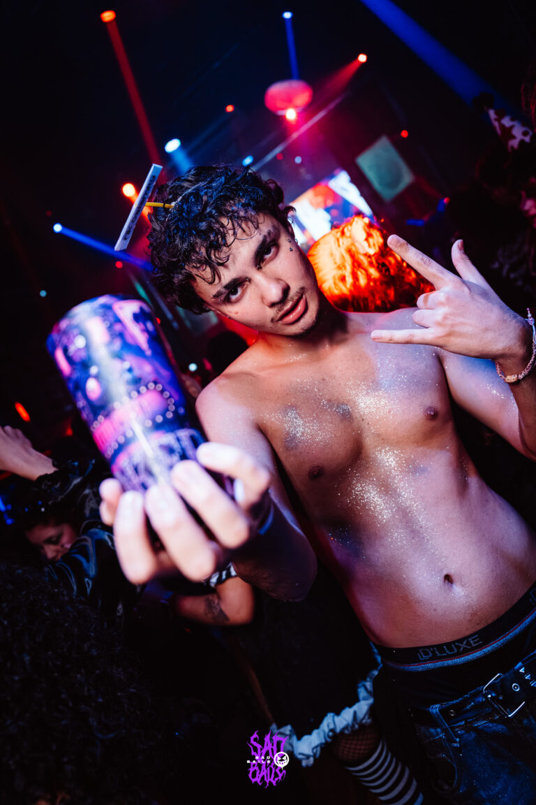 Rapaz sem camisa estende copo Joker — Sad Baile Joker, Halloween em São Paulo, 17/10/2026