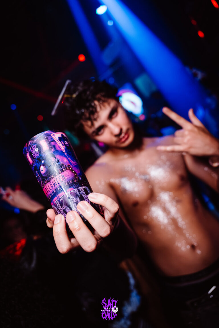 Rapaz sem camisa faz sinal de rock com copo Joker — Sad Baile Joker, Halloween em São Paulo, 17/10/2026