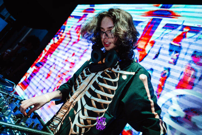 DJ de jaqueta de esqueleto sorri na cabine — Sad Baile Joker, Halloween em São Paulo, 17/10/2026