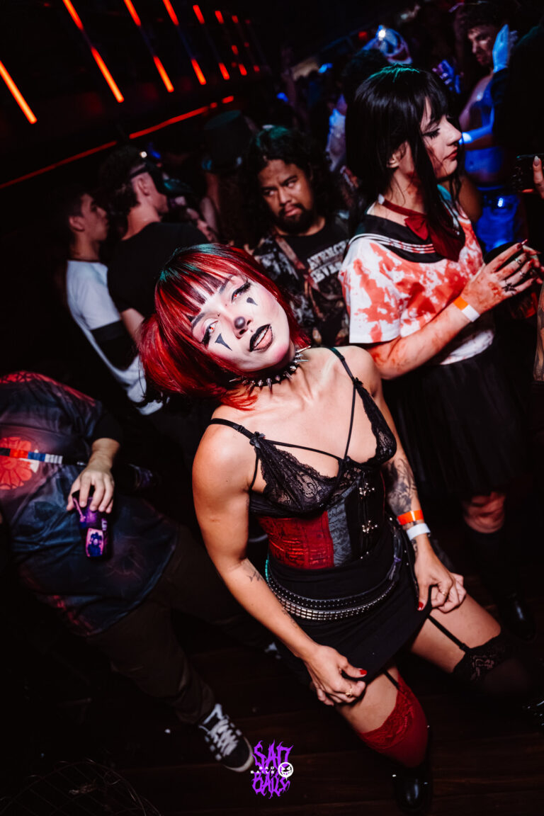 Garota de cabelo vermelho e corpete preto dança — Sad Baile Joker, Halloween em São Paulo, 17/10/2026