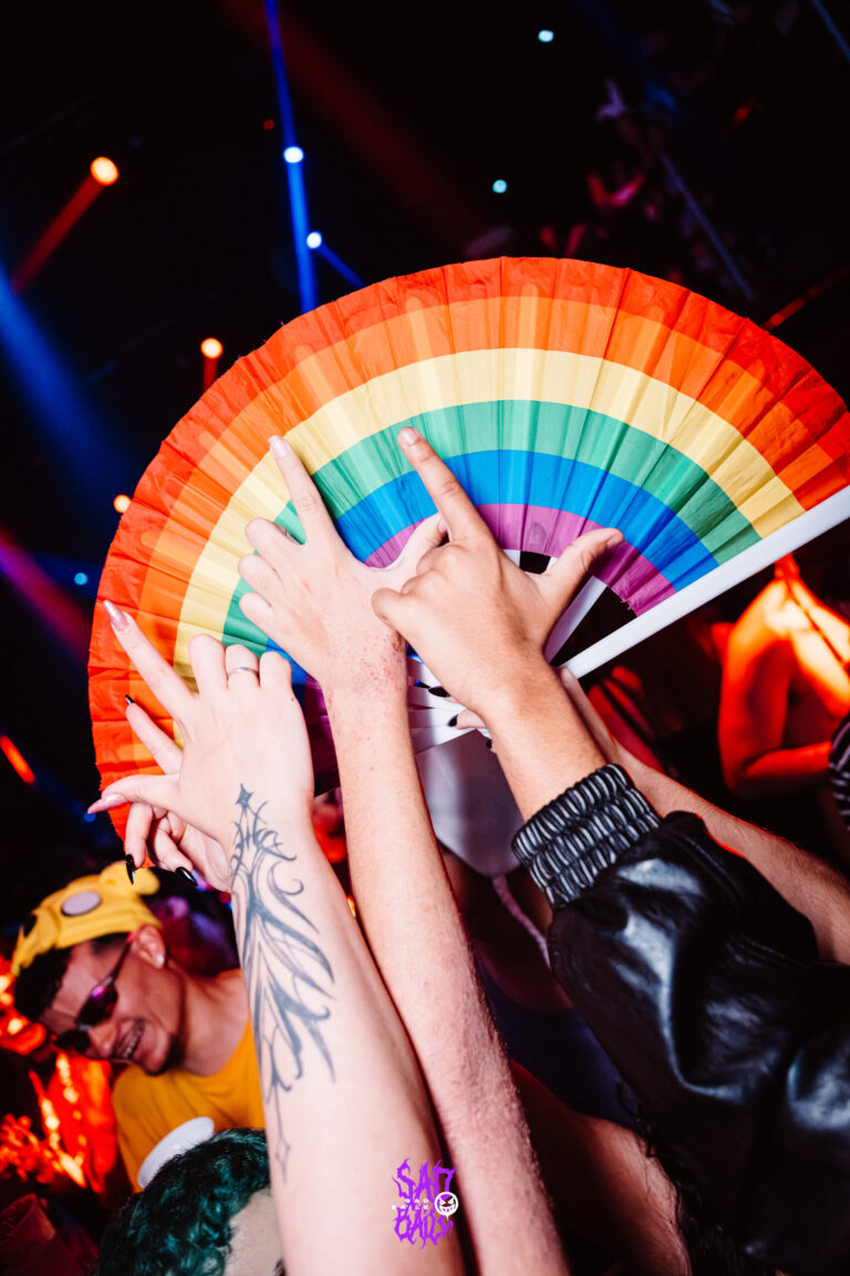 Mãos e leque colorido na pista lotada — Sad Baile Joker, Halloween em São Paulo, 17/10/2026