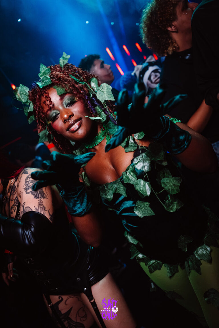Hera Venenosa de folhas verdes sob luz azul — Sad Baile Joker, Halloween em São Paulo, 17/10/2026