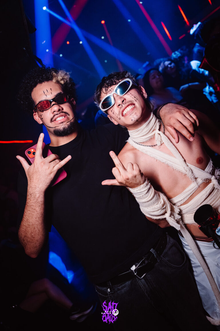 Amigos de óculos escuros fazem sinal de rock — Sad Baile Joker, Halloween em São Paulo, 17/10/2026