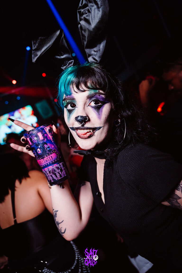 Garota de maquiagem de gato e cabelo azul com copo Joker — Sad Baile Joker, Halloween em São Paulo, 17/10/2026