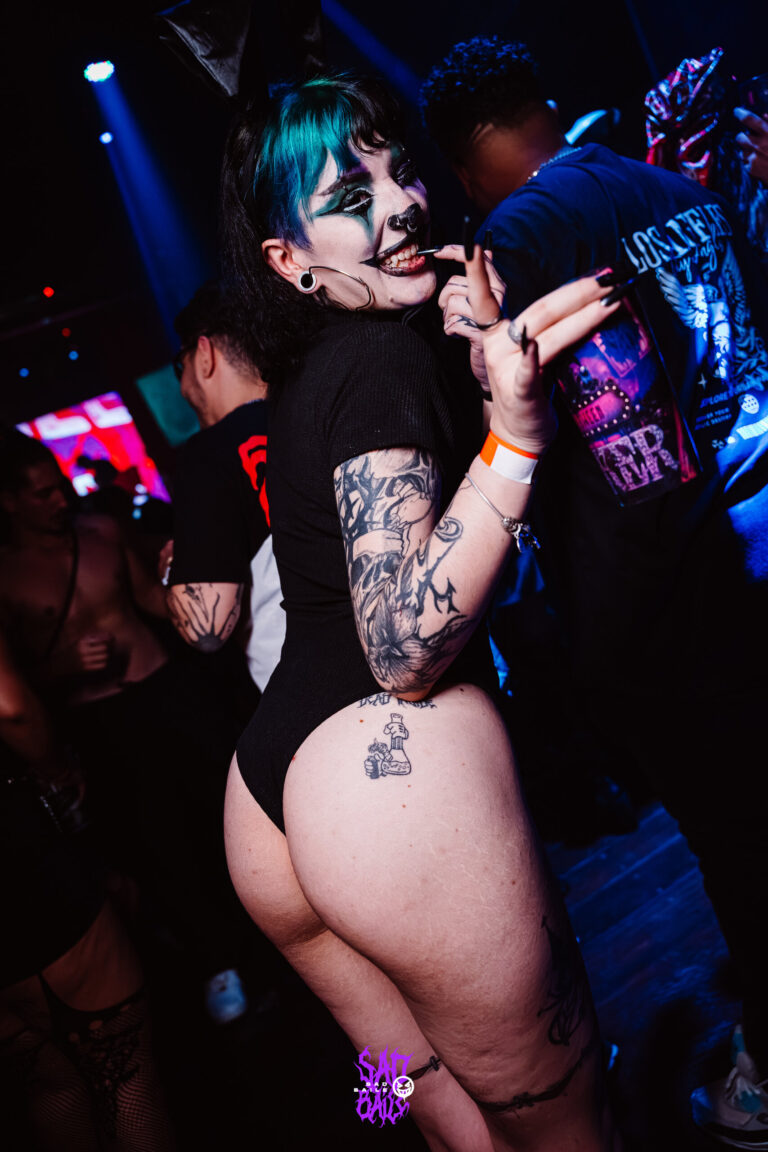Garota de cabelo azul e body preto com copo Joker — Sad Baile Joker, Halloween em São Paulo, 17/10/2026