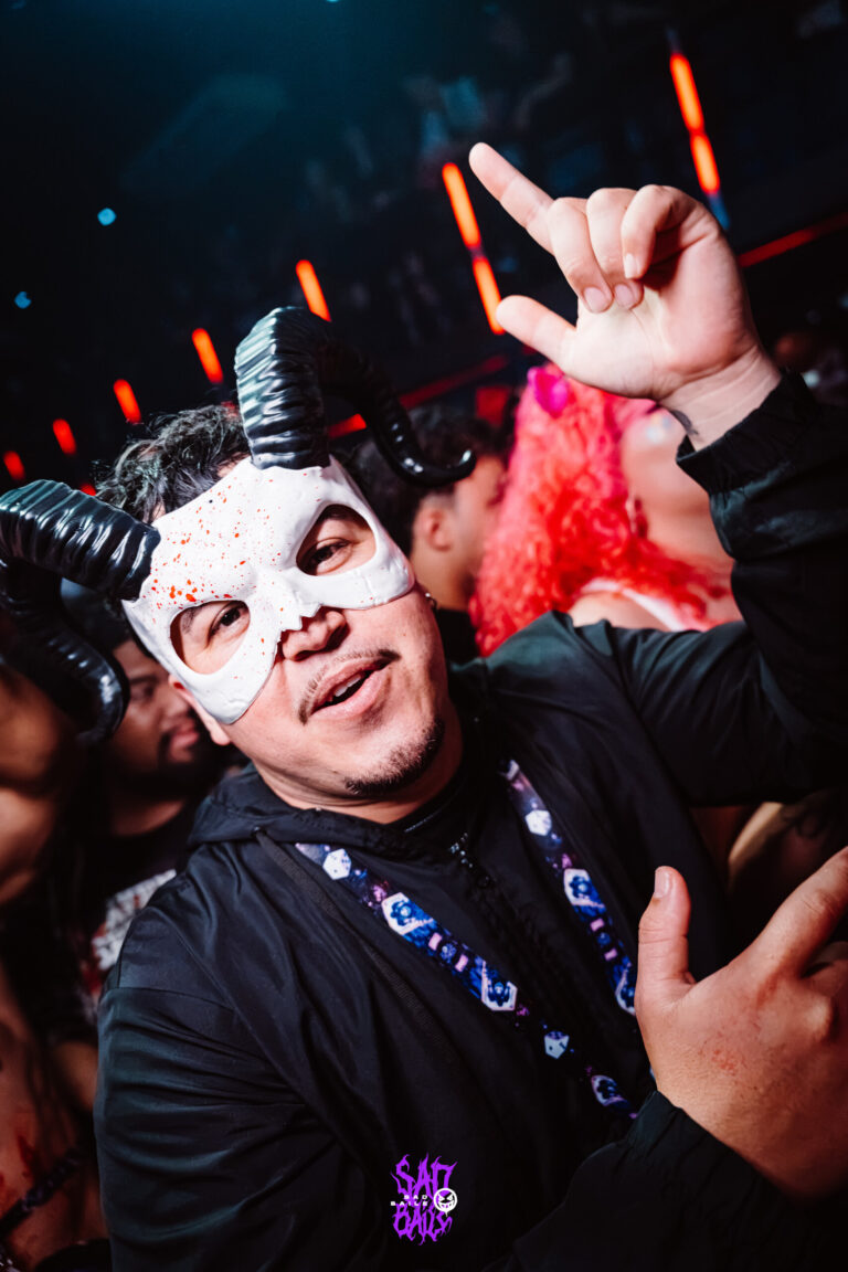 Rapaz de máscara de caveira com chifres faz sinal — Sad Baile Joker, Halloween em São Paulo, 17/10/2026