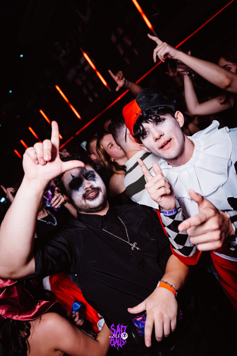 Amigos fantasiados fazem sinal de L na pista — Sad Baile Joker, Halloween em São Paulo, 17/10/2026