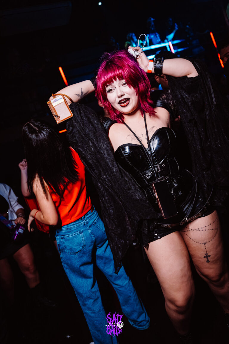 Garota de cabelo pink faz pose com a mão na cabeça — Sad Baile Joker, Halloween em São Paulo, 17/10/2026