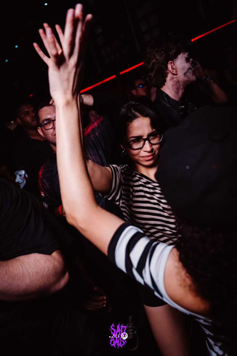 Garota de óculos dança com o braço erguido — Sad Baile Joker, Halloween em São Paulo, 17/10/2026