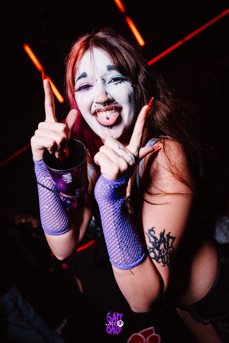 Garota de rosto pintado mostra a língua e faz sinal de paz — Sad Baile Joker, Halloween em São Paulo, 17/10/2026