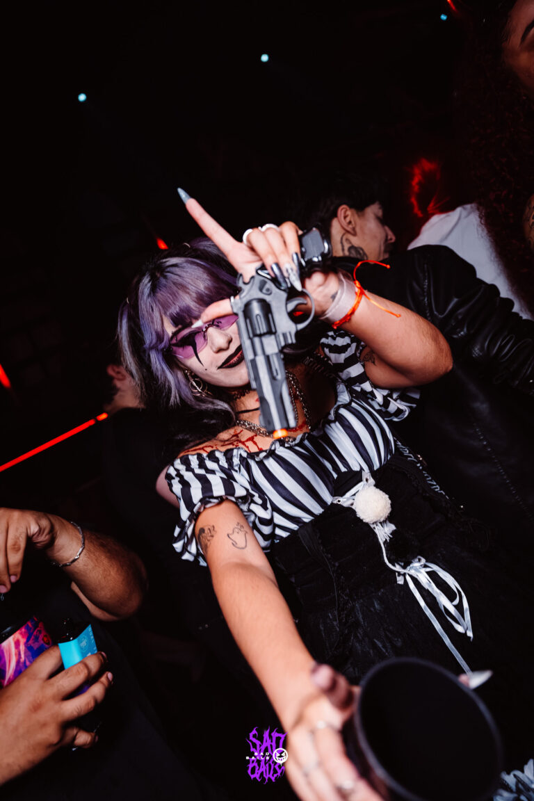 Palhaça de peruca lilás aponta para a câmera — Sad Baile Joker, Halloween em São Paulo, 17/10/2026