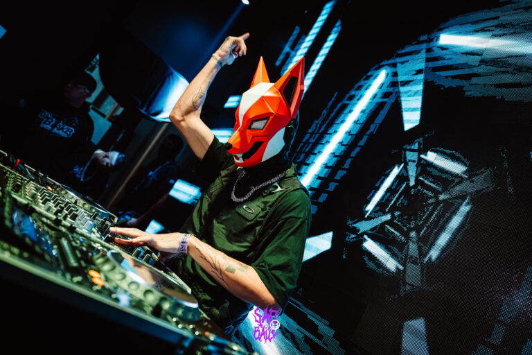 DJ com máscara de raposa sob luzes azuis — Sad Baile Joker, Halloween em São Paulo, 17/10/2026