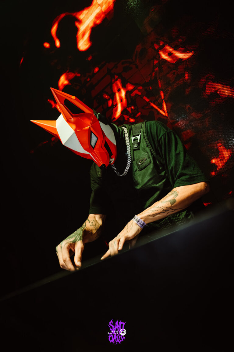 DJ de máscara de raposa sob luz laranja — Sad Baile Joker, Halloween em São Paulo, 17/10/2026