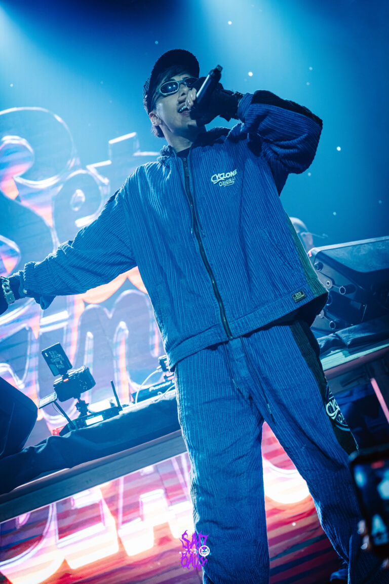 Rapper de conjunto azul abre os braços — Sad Baile Joker, Halloween em São Paulo, 17/10/2026