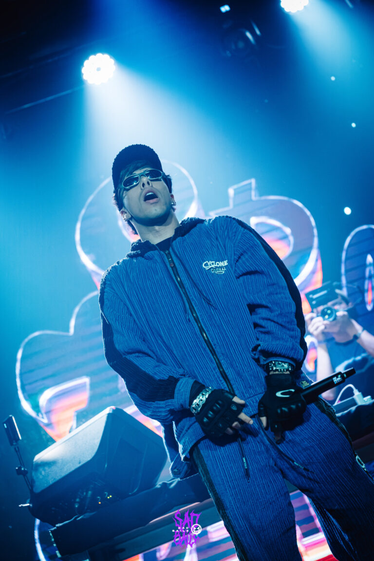Rapper de boné canta sob luzes azuis — Sad Baile Joker, Halloween em São Paulo, 17/10/2026