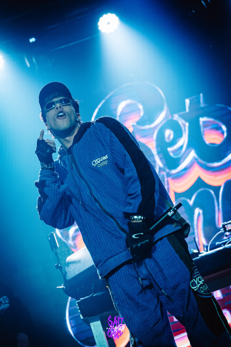 Rapper de conjunto azul canta diante do telão — Sad Baile Joker, Halloween em São Paulo, 17/10/2026