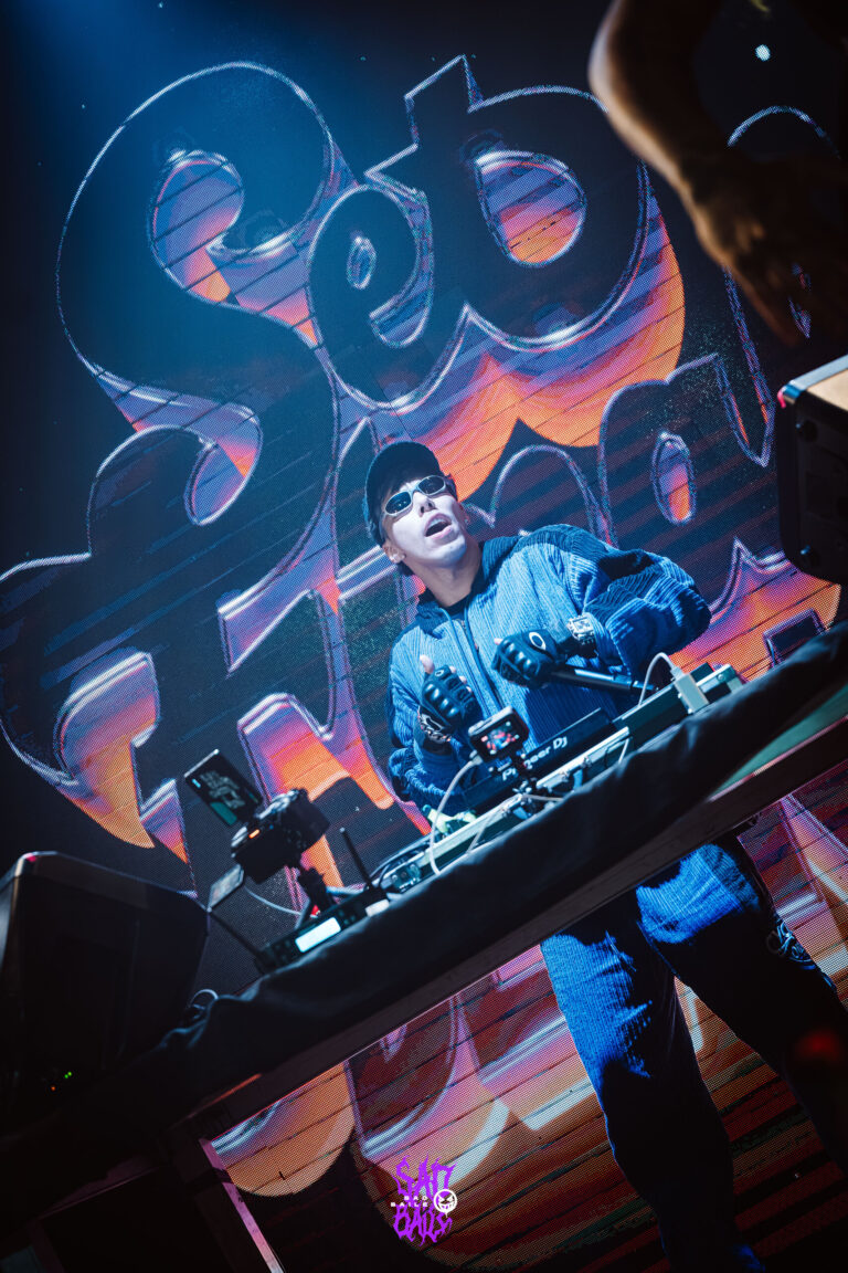 Rapper no palco com o telão grafitado — Sad Baile Joker, Halloween em São Paulo, 17/10/2026