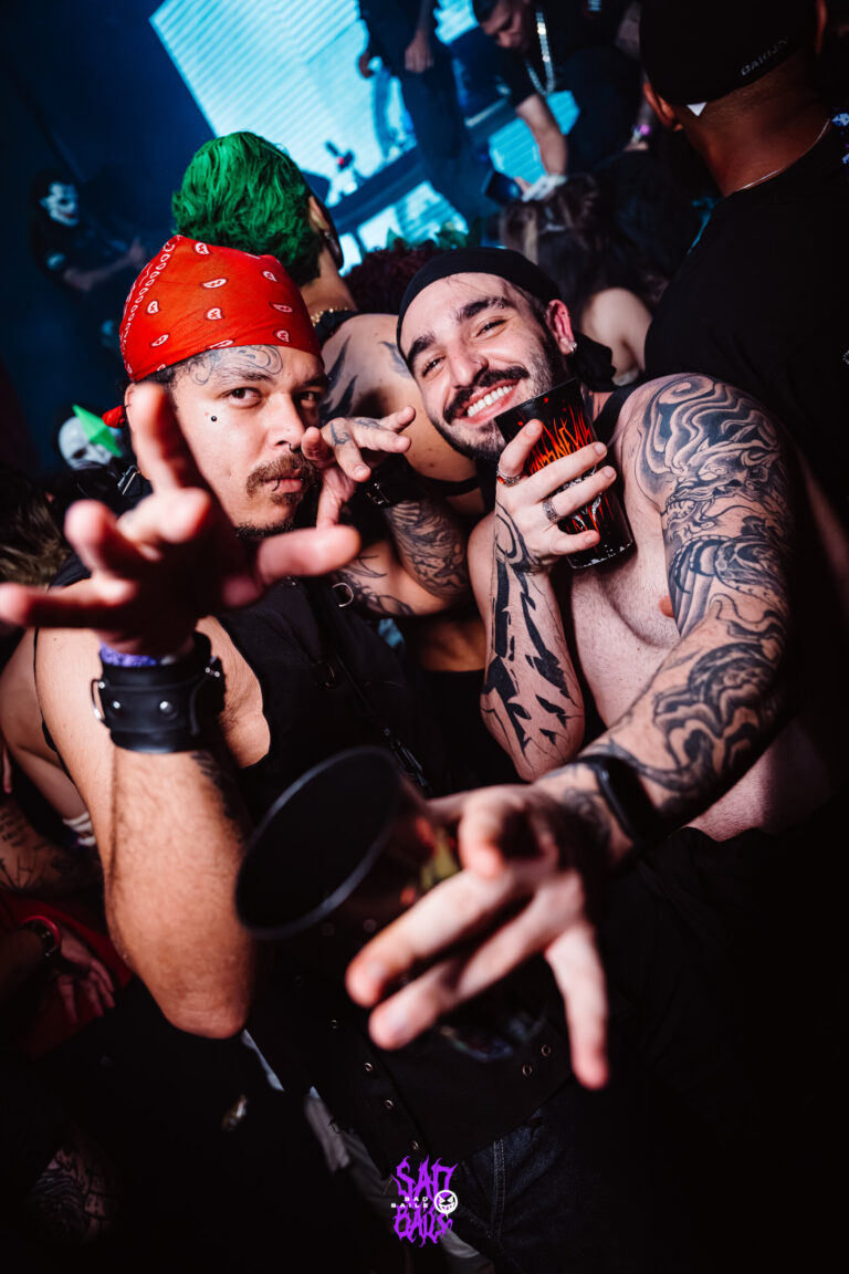 Amigos tatuados estendem as mãos para a câmera — Sad Baile Joker, Halloween em São Paulo, 17/10/2026