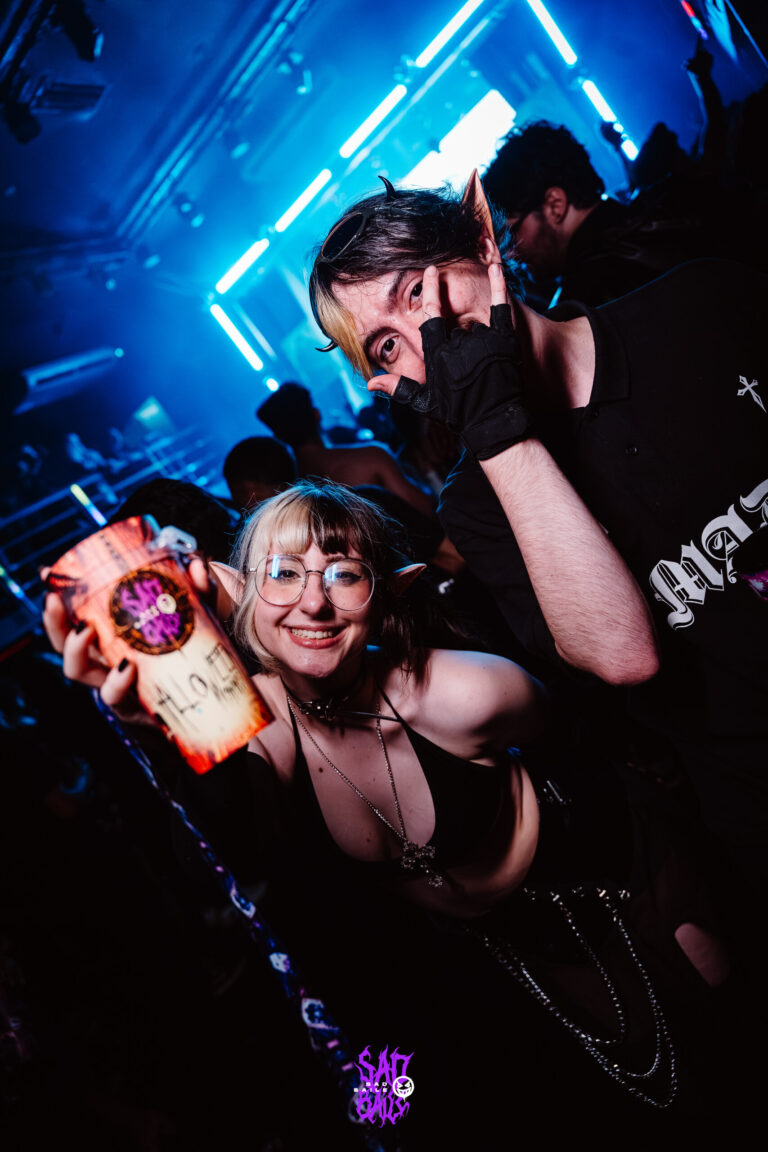 Amigos posam com copo na pista sob luz azul — Sad Baile Joker, Halloween em São Paulo, 17/10/2026
