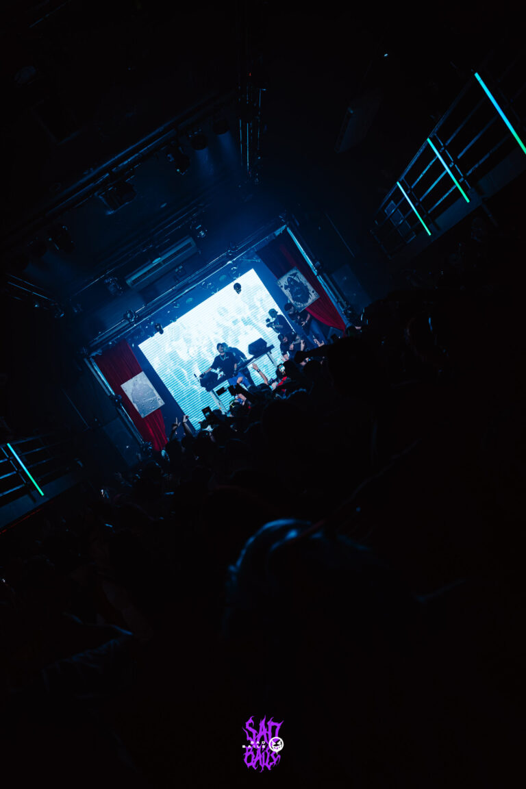 Palco iluminado visto do fundo da pista escura — Sad Baile Joker, Halloween em São Paulo, 17/10/2026