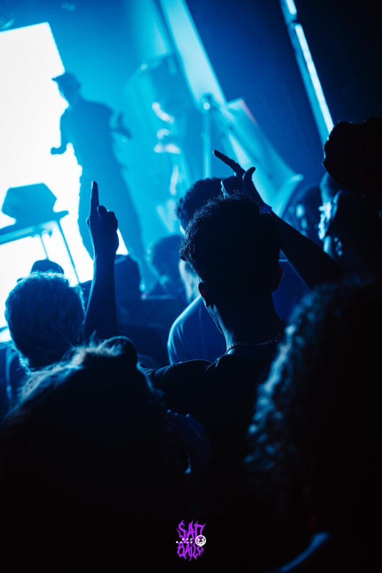 Público de braços erguidos na contraluz — Sad Baile Joker, Halloween em São Paulo, 17/10/2026