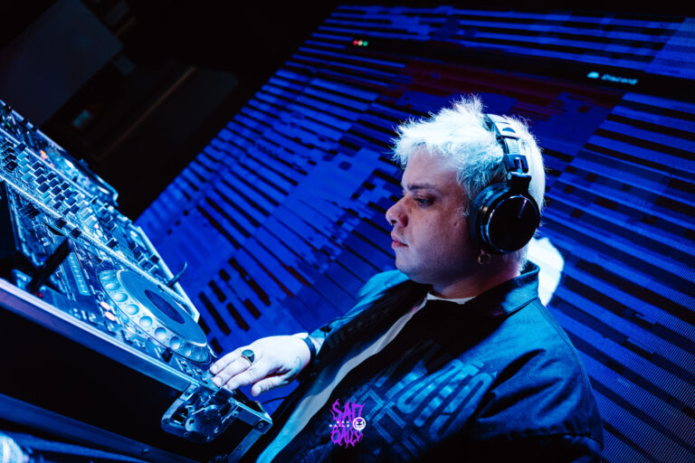 DJ de fones toca sob luz azul — Sad Baile Joker, Halloween em São Paulo, 17/10/2026