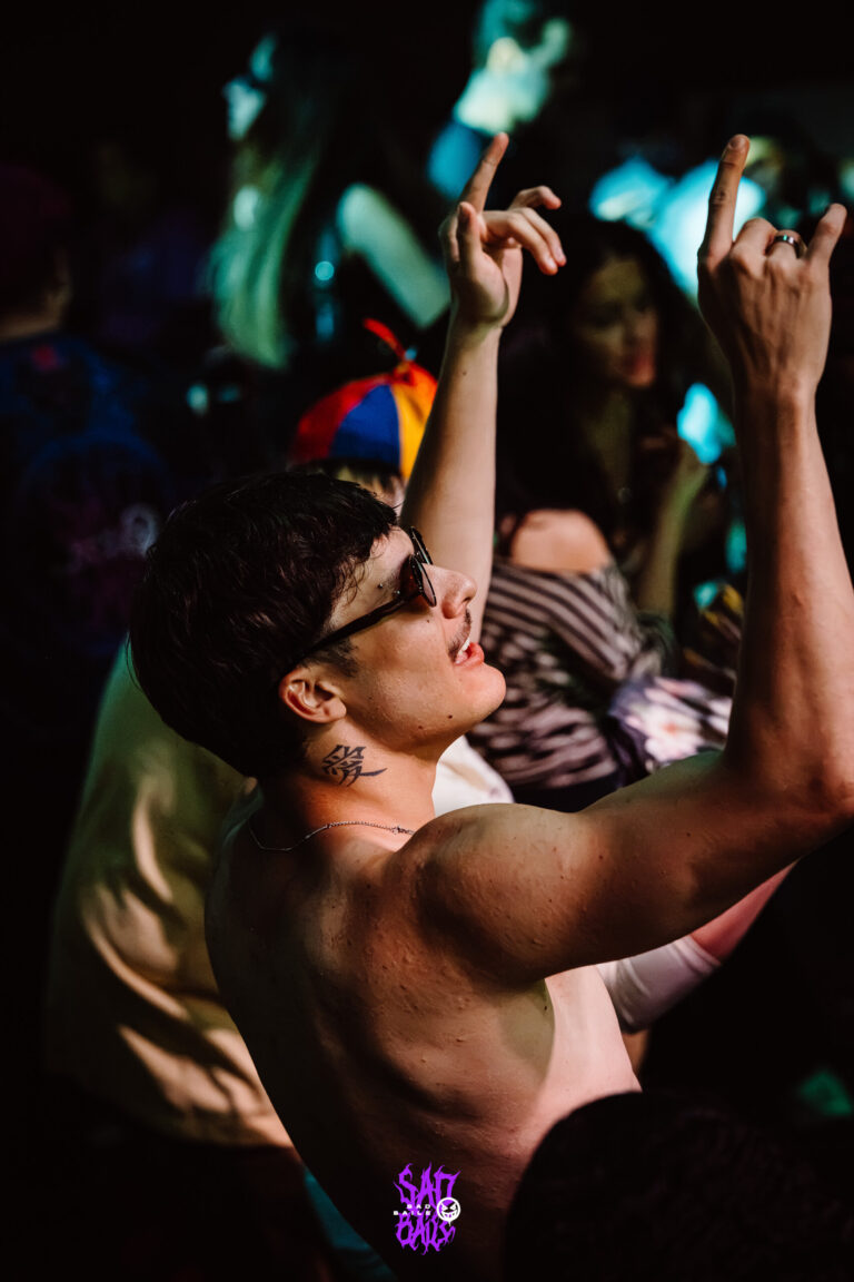 Rapaz sem camisa dança com os braços erguidos — Sad Baile Joker, Halloween em São Paulo, 17/10/2026
