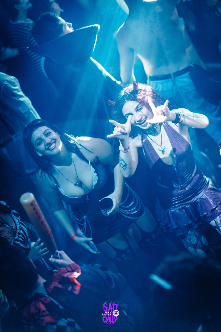 Garota dança sob luz azul com o braço estendido — Sad Baile Joker, Halloween em São Paulo, 17/10/2026