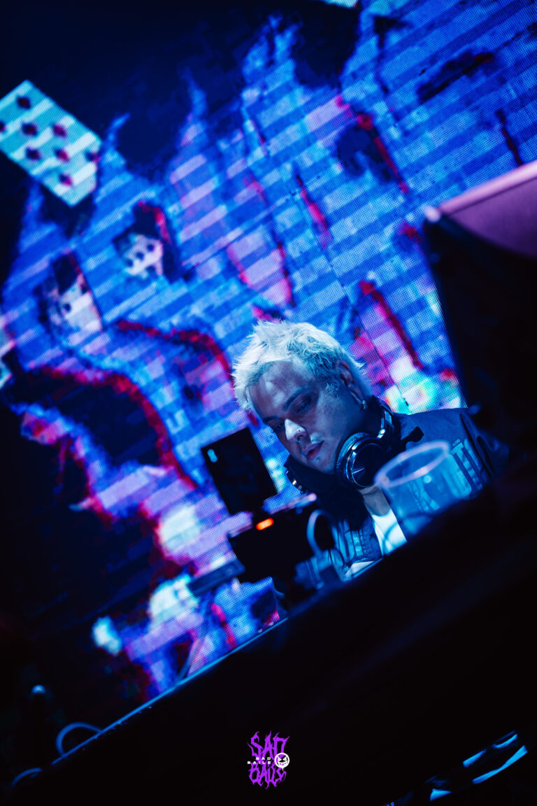 DJ concentrado com o telão de cartas ao fundo — Sad Baile Joker, Halloween em São Paulo, 17/10/2026