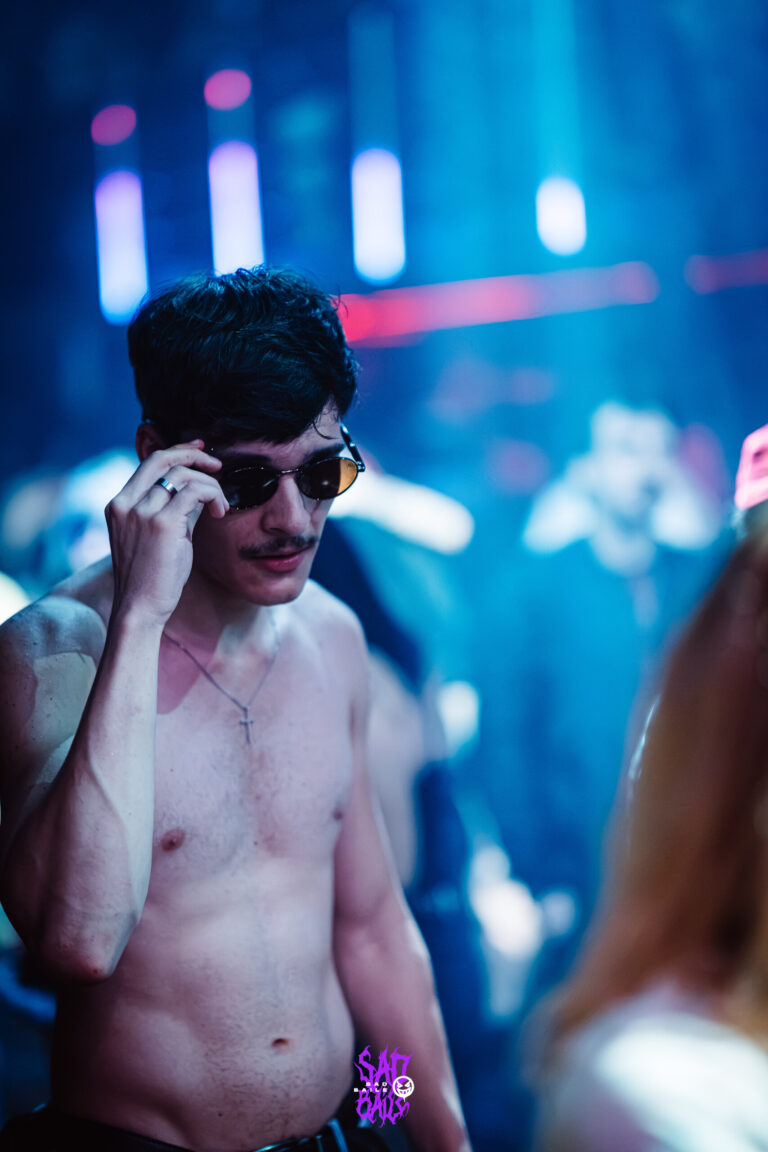 Rapaz de óculos escuros ajeita os óculos — Sad Baile Joker, Halloween em São Paulo, 17/10/2026