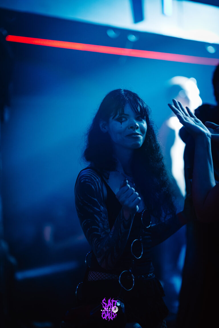 Garota de cabelo comprido dança sob luz azul — Sad Baile Joker, Halloween em São Paulo, 17/10/2026